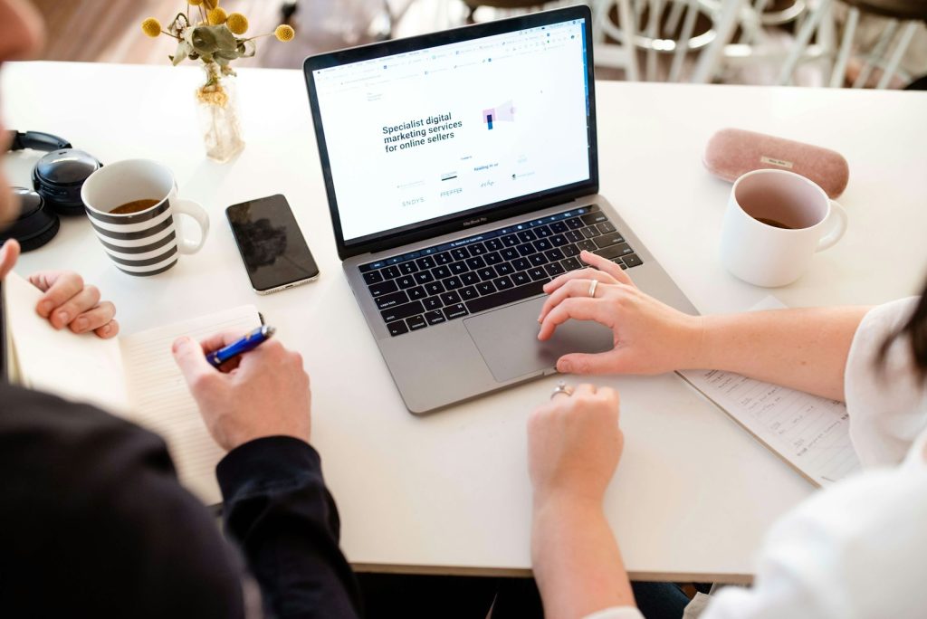 Mentor and learner working through a task together on a laptop, seen from above