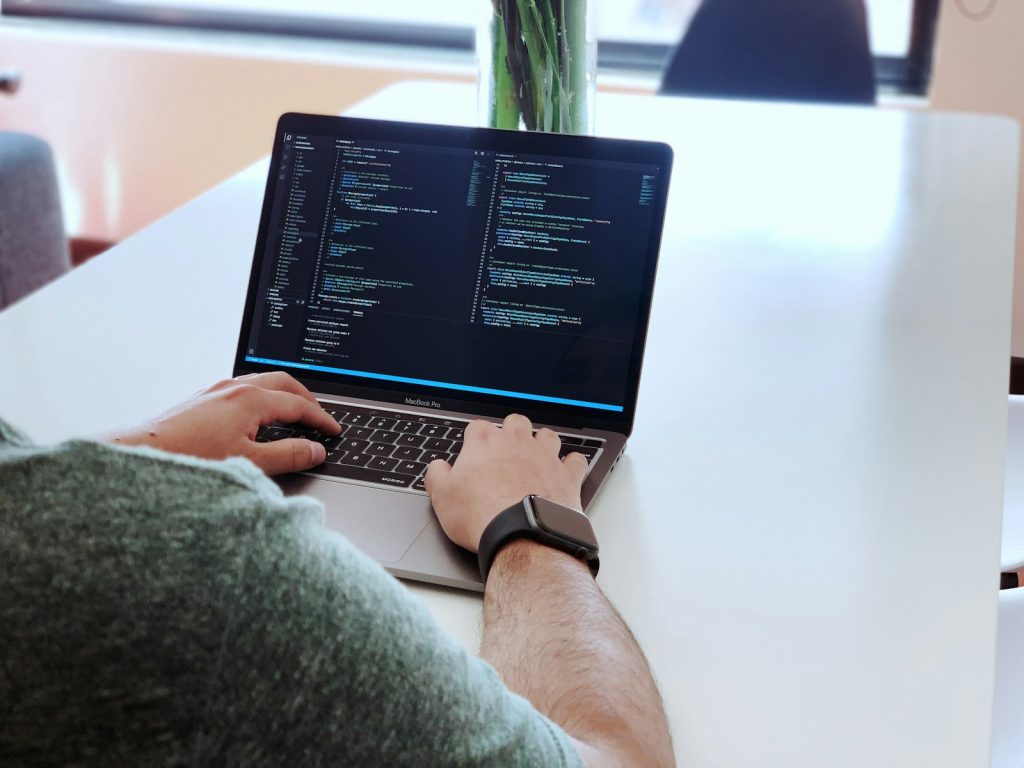 Hands writing Python code on a laptop, week one of the generative AI course in Pune